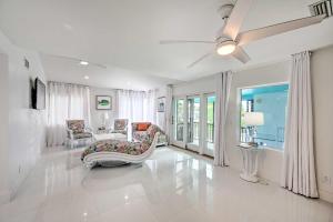 Sala de estar blanca con sofá y silla en Waterfront Marco Island House with Shared Dock! en Marco Island