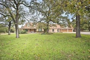 a house in a field with trees in front of it at Gainesville Home with Outdoor Oasis, 16 Mi to Lake in Gainesville