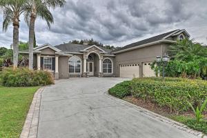 a large house with a driveway and palm trees at Elegant Valrico Home about 15 Mi to Downtown Tampa! in Valrico