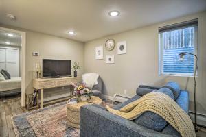 sala de estar con sofá azul y TV en Alluring Anchorage Apt - Walk to Coastal Trl!, en Anchorage