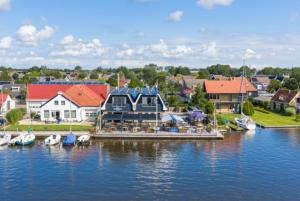 un puerto deportivo con barcos en el agua junto a las casas en Appartementen De Helling 44, en Heeg