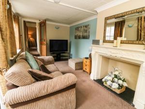 a living room with a couch and a fireplace at Blacksmiths Retreat, 50 Holgate Road in York
