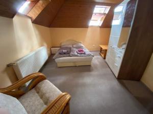 ein kleines Schlafzimmer mit einem Bett und einem Kühlschrank in der Unterkunft Fenyves Sor Apartman in Orfű