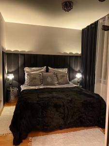 a bedroom with a large bed with a black headboard at Comfort Zone Ostróda CITY & LAKE in Ostróda