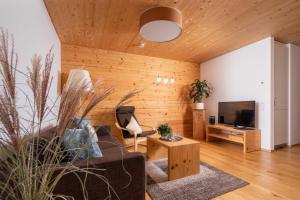 a living room with a couch and a television at Appartements Veronika in Silbertal