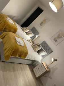 um quarto com 2 camas com cobertores e almofadas dourados em Elevate at Fleet Heights Apartment Seven em Fleet