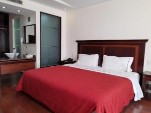 a bedroom with a large bed with a red blanket at HOTEL MADEIRA in Mexico City