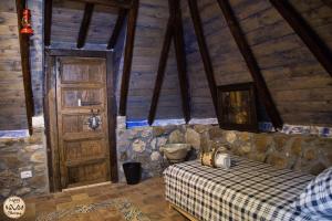 sypialnia z łóżkiem i drewnianymi drzwiami w obiekcie HAPPY GLAMPING MADONIE w mieście Polizzi Generosa