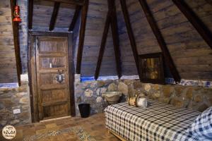 a bedroom with a bed and a wooden door at HAPPY GLAMPING MADONIE in Polizzi Generosa
