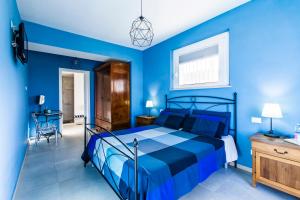 Dormitorio azul con cama y escritorio en B&B Al Chicco d'Uva, en Morro dʼAlba