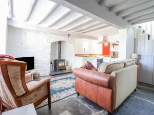 a living room with a couch and a fireplace at 1 Hendom in Corwen