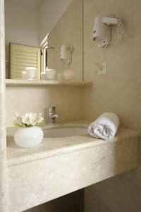 ein Bad mit einem Waschbecken und einem Handtuch in der Unterkunft Glaros Hotel Apartment in Agia Galini