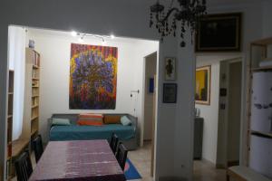 a living room with a table and a painting on the wall at Appartement atelier d'artiste in Vanves