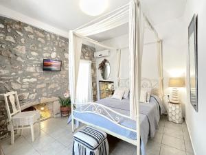 a bedroom with a canopy bed and a fireplace at Four Seasons of Bliss at Sohora Hotel in Rethymno