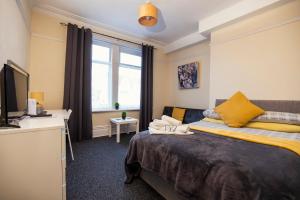 a bedroom with a bed and a desk and a television at Dunes Hotel in Whitley Bay