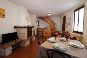 a dining room with a table and a fireplace at Ca' Marietta al Centro Storico in Borno