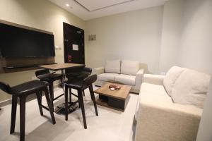 a living room with a couch and a table at فندق صحارى الخليج Sahara Gulf Hotel Apartments in Amman