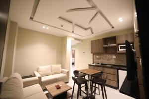 a living room with a couch and a table at فندق صحارى الخليج Sahara Gulf Hotel Apartments in Amman
