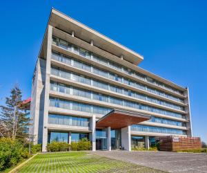 un edificio per uffici con un prato davanti di Wyndham Concepcion Pettra a Concepción