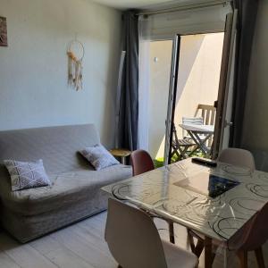 a living room with a table and a couch at apt cosy, 4 pers, plein centre ville, parking offert in Font-Romeu-Odeillo-Via