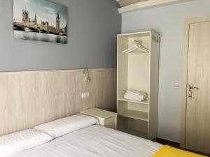 sypialnia z łóżkiem i zdjęciem na ścianie w obiekcie Alojamiento HC w mieście Colmenar Viejo