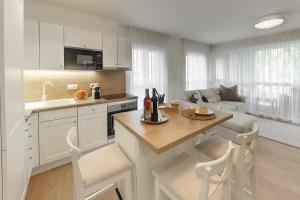 a kitchen with white cabinets and a table and chairs at Cosy inner city getaway bestern in Szeged