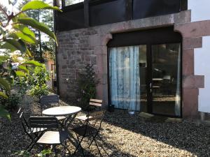 une terrasse avec une table et des chaises devant un bâtiment dans l'établissement Logis Du Haut-Koenigsbourg, à Thannenkirch