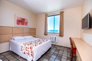 a bedroom with a bed and a tv and a window at Hotel Dan Inn Express Salvador in Salvador