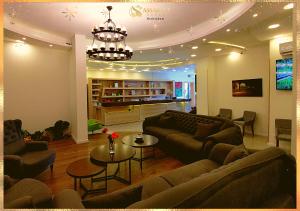 un soggiorno con divani, tavoli e lampadario a braccio di Assaraya Palace Hotel a Bethlehem