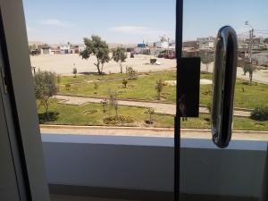 a window with a view of a park through it at Hostel Willys House in Paracas