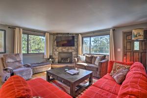 a living room with a red couch and a fireplace at Luxe Updated Home with Grill and Hot Tub 4 Mi to RMNP in Estes Park