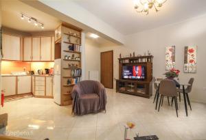 a kitchen and living room with a table and a television at Marys house in Markopoulo