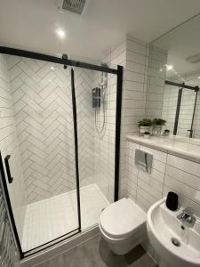 a bathroom with a shower and a toilet and a sink at Kempston Suites Liverpool Apartment 10 in Liverpool +2 photos