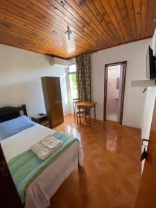 a bedroom with a bed and a wooden ceiling at Hotel Ibajé in Bagé