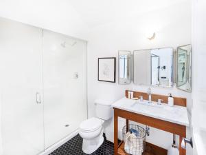 a bathroom with a toilet and a sink and a shower at American Beech Hotel in Greenport