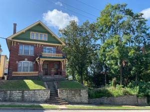 a red brick house with a green roof at The Edmond an 1887 Arts & Crafts gem in Saint Joseph