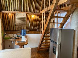 a kitchen with a staircase leading up to a refrigerator at Cabañas Aldea San Francisco de Asís in Cuetzalán del Progreso