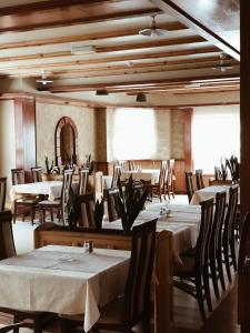 un restaurante con mesas y sillas con manteles blancos en Hotel Kupres, en Kupres