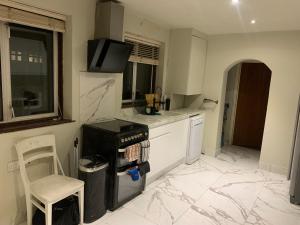 cocina con suelo de mármol y fogones horno superior en Superb Double Bedroom en Londres