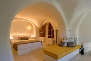 a bedroom with two beds in a room with an archway at Potamos Luxury House, Private Pool, Santorini in Éxo Goniá