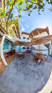 un patio con mesas y sombrillas frente a un edificio en Pousada Coração do Arraial, en Arraial d'Ajuda