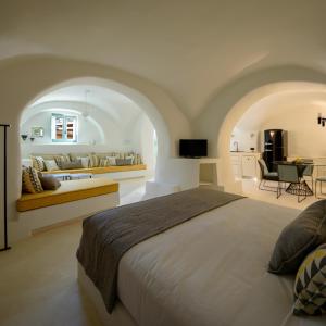 Éxo GoniáにあるPotamos Luxury House, Private Pool, Santoriniのベッドルーム(大型ベッド1台付)、リビングルームが備わります。