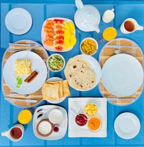 una mesa azul cubierta con platos y tazones de comida en Blinkbonnie Inn, en Kandy