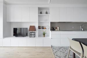 a kitchen with white cabinets and a tv at Aldamar Old Town - Romantic Historic Centre in San Sebastián