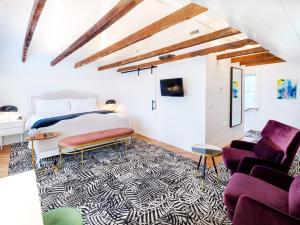 a bedroom with a bed and a living room at American Beech Hotel in Greenport