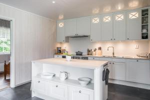uma cozinha com armários brancos e uma bancada em Solar Lake Cottage em Jönköping