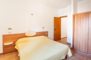 a bedroom with a bed with a yellow blanket on it at Villaggio Camping Oasi in Vieste