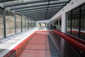 un largo pasillo con un banco rojo y ventanas en Eira do Serrado - Hotel & Spa, en Curral das Freiras