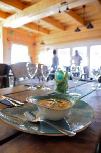 drewniany stół z miską zupy i kieliszkami do wina w obiekcie Rybaczówka Karczma Rybna w Świnoujściu