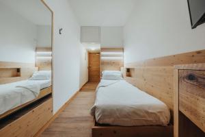 a bed room with two beds and a desk at Hotel Olimpia in Cortina dʼAmpezzo